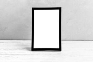 White wooden floor over concrete or decorative plaster wall and black photo frame with copy space for a text background. Mock up.