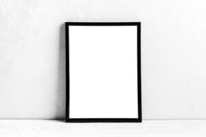 White wooden floor over concrete or decorative plaster wall and black photo frame with copy space for a text background. Mock up.