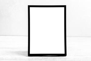 White wooden floor over concrete or decorative plaster wall and black photo frame with copy space for a text background. Mock up.