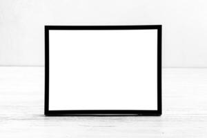 White wooden floor over concrete or decorative plaster wall and black photo frame with copy space for a text background. Mock up.