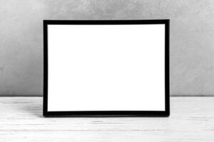 White wooden floor over concrete or decorative plaster wall and black photo frame with copy space for a text background. Mock up.