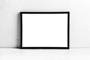 White wooden floor over concrete or decorative plaster wall and black photo frame with copy space for a text background. Mock up.