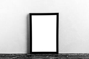 Wooden floor over concrete or decorative plaster wall and black photo frame with copy space for a text background. Mock up.