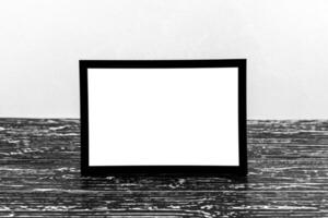 Wooden floor over concrete or decorative plaster wall and black photo frame with copy space for a text background. Mock up.