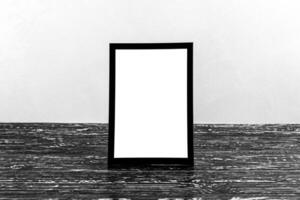 Wooden floor over concrete or decorative plaster wall and black photo frame with copy space for a text background. Mock up.