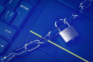 Black keyword and metal chain with lock. The concept of blocking or ban electronic money, e-business, mining, gaming or internet. Computer security or data protection. photo