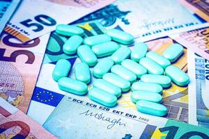 Green pills on the background of euro bills. The concept of the expensive cost of healthcare or financing medicine. photo