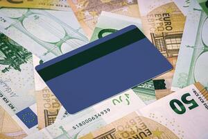 Euro bills and blue debit card with copy space for a text. The concept of electronic money and commerce. The concept of buying things on credit. Background or mock up for design. photo
