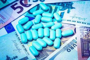 Green pills on the background of euro bills. The concept of the expensive cost of healthcare or financing medicine. photo