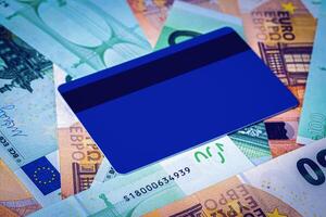 Euro bills and blue debit card with copy space for a text. The concept of electronic money and commerce. The concept of buying things on credit. Background or mock up for design. photo