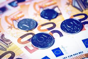Ruble coins on the background of euro bills. photo
