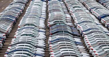 Rows of a new cars parked in a distribution center of a car factory. Top view to the parking in the open air. photo