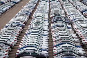 Rows of a new cars parked in a distribution center of a car factory. Top view to the parking in the open air. photo