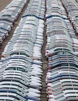 Rows of a new cars parked in a distribution center on a cloudy day in the spring, a car factory. Top view to the parking in the open air. photo