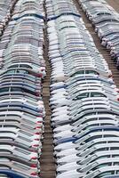 Rows of a new cars parked in a distribution center of a car factory. Top view to the parking in the open air. photo