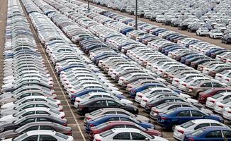 Rows of a new cars parked in a distribution center on a cloudy day in the spring, a car factory. Top view to the parking in the open air. photo