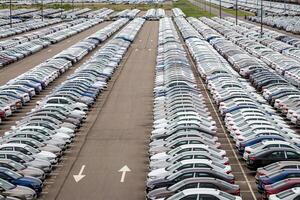 Rows of a new cars parked in a distribution center of a car factory. Top view to the parking in the open air. photo