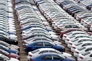 Rows of a new cars parked in a distribution center of a car factory. Top view to the parking in the open air. photo