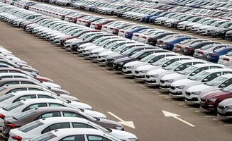 Rows of a new cars parked in a distribution center of a car factory. Top view to the parking in the open air. photo