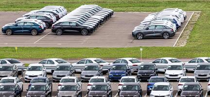Volkswagen Group Rus, Russia, Kaluga - MAY 24, 2020 Rows of a new cars parked in a distribution center on a cloudy day in the spring, a car factory. Parking in the open air. photo