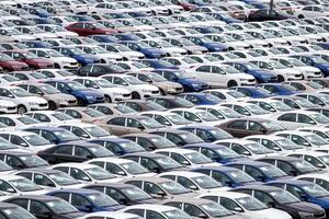 Rows of a new cars parked in a distribution center on a car factory on a cloudy day. Top view to the parking in the open air. photo