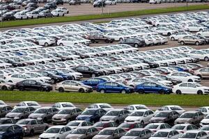 Volkswagen Group Rus, Russia, Kaluga - MAY 24, 2020 Rows of a new cars parked in a distribution center on a cloudy day in the spring, a car factory. Top view to the parking in the open air. photo