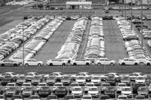 Volkswagen Group Rus, Russia, Kaluga - MAY 24, 2020 Rows of a new cars parked in a distribution center on a cloudy day in the spring and a car factory buildings. Parking in the open air. photo