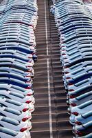 Rows of a new cars parked in a distribution center on a car factory on a sunny day. Top view to the parking in the open air. photo