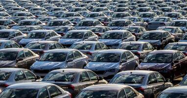 Volkswagen Group Rus, Russia, Kaluga - MAY 25, 2020 Rows of a new cars parked in a distribution center on a sunny day in the spring. Top view to a parking in the open air. photo