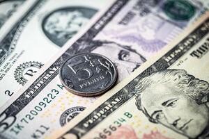 Five-ruble coin on the background of dollar bills. photo