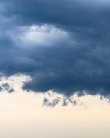 Dark blue heavy storm clouds before a thunderstorm or hurricane. Dramatic clouds in overcast weather. photo