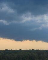Dark blue heavy storm clouds before a thunderstorm or hurricane. Dramatic clouds in overcast weather. photo