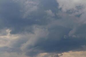 Dark blue heavy storm clouds before a thunderstorm or hurricane. Dramatic clouds in overcast weather. photo