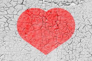 Red heart on a cracked texture. The concept of broken heart and the end of love. photo