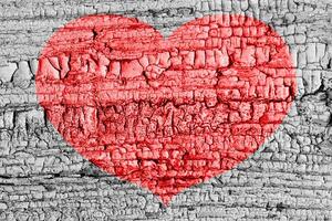 Red heart on a cracked texture. The concept of broken heart and the end of love. photo