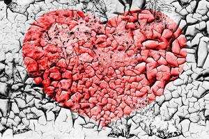 Red heart on a cracked texture. The concept of broken heart and the end of love. photo