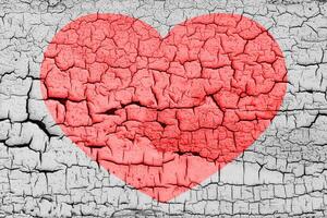 Red heart on a cracked texture. The concept of broken heart and the end of love. photo