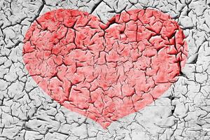 Red heart on a cracked texture. The concept of broken heart and the end of love. photo