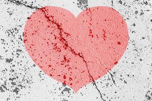 Red heart on a cracked texture. The concept of broken heart and the end of love. photo