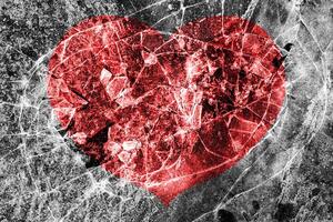 Red heart on a cracked texture. The concept of broken heart and the end of love. photo