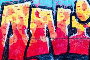 A fragment of colorful graffiti painted on a concrete wall. Abstract urban backdrop for design. photo