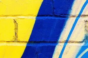 A fragment of colorful graffiti painted on a brick wall. Abstract backdrop for design. photo