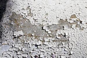 Texture of old white peeling paint on a concrete surface. Abstract backdrop for design. photo