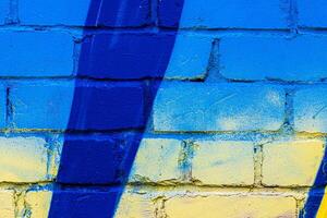 A fragment of colorful graffiti painted on a brick wall. Abstract backdrop for design. photo
