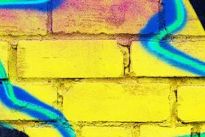 A fragment of colorful graffiti painted on a brick wall. Abstract backdrop for design. photo