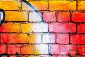 A fragment of colorful graffiti painted on a brick wall. Abstract backdrop for design. photo