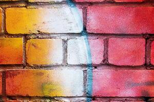 A fragment of colorful graffiti painted on a brick wall. Abstract backdrop for design. photo