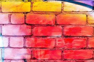 A fragment of colorful graffiti painted on a brick wall. Abstract backdrop for design. photo