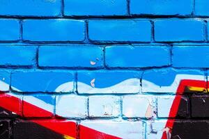 A fragment of colorful graffiti painted on a brick wall. Abstract backdrop for design. photo