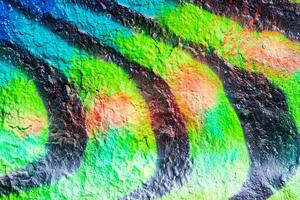 A fragment of colorful graffiti painted on a concrete wall. Abstract urban backdrop for design. photo